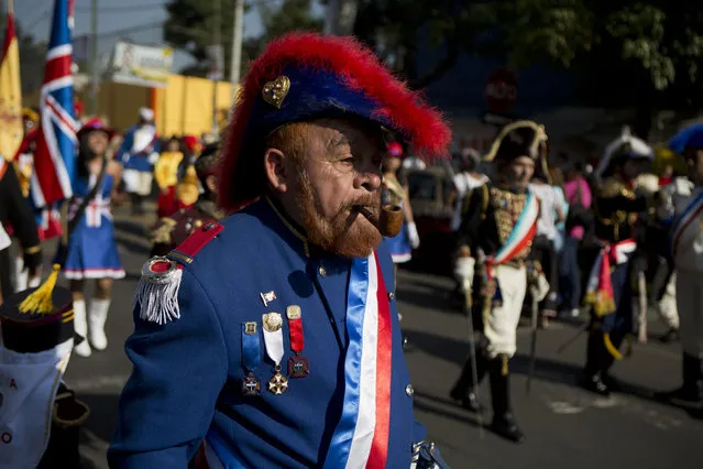 Mexicans dressed as French Army officers walk in a parade ahead of a reenactment of the battle of Puebla between Zacapoaxtla Indians and the French army during Cinco de Mayo celebrations in the Penon de los Banos neighborhood of Mexico City, Tuesday, May 5, 2015. (Photo by Rebecca Blackwell/AP Photo)
