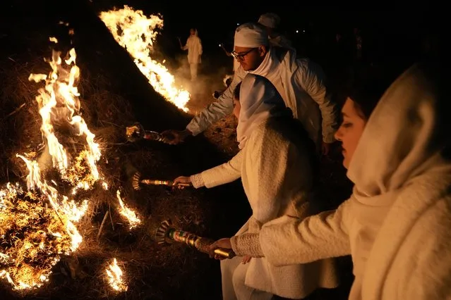 Iranian Zoroastrian youth set fire to a prepared pile of wood in a ceremony celebrating their ancient mid-winter Sadeh festival in the outskirts of Tehran, Iran, Tuesday, January 30, 2024. (Photo by Vahid Salemi/AP Photo)