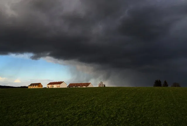 Dark rain clouds cut across the blue sky near Duerroehrsdorf, Germany, 03 February 2016. (Photo by Arno Burgi/EPA)