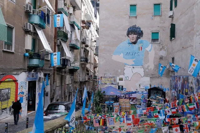 A general view shows a mural painting of late Argentinian football legend Diego Maradona at the so-called “Maradona square” in the Quartieri Spagnoli district of Naples on November 23, 2021. In the hearts, on the walls and on the shirts: Maradona is still everywhere in Naples. And on November 25, 2021, the first anniversary of his death, a bronze statue will be installed in front of the stadium bearing his name to celebrate the “eternal” link between the Italian city and the “Pibe de Oro”. (Photo by Carlo Hermann/AFP Photo)