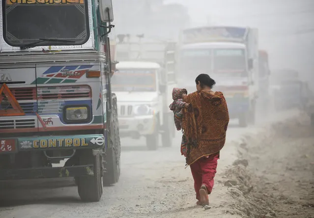 A woman carrying her child walks along the dusty road in Kathmandu, Nepal February 27, 2017. (Photo by Navesh Chitrakar/Reuters)