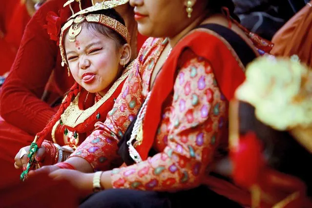 Girl in newari attire makes a funny face to her friend as she performs a Mass Bel Bibaha (marriage) ceremony in Bhaktapur, Bagmati, Nepal on December 7, 2021. The two-day ceremony, usually held several times a year, sees pre-adolescent “marry” the Hindu deity, Vishnu, symbolised by the local “bael” (wood apple) fruit. Normally Newar girls marry thrice time in there life as first marriage with Bael fruit, second with sun and third with human. (Photo by Amit Machamasi/ZUMA Wire/Alamy Live News)