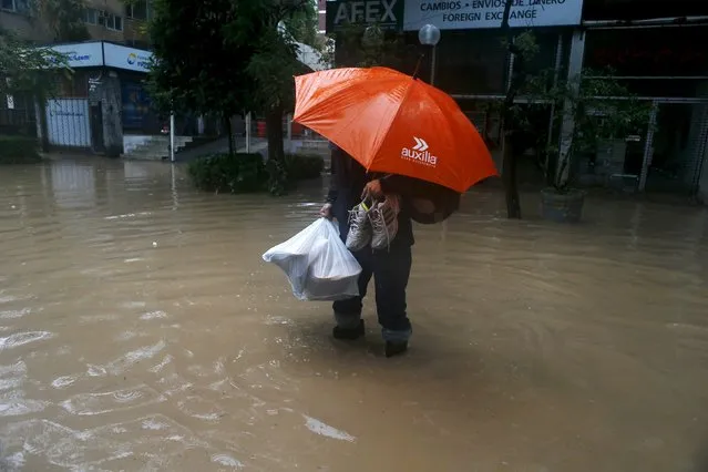 A man crosses a flooded a street in Santiago, April 17, 2016. (Photo by Ivan Alvarado/Reuters)