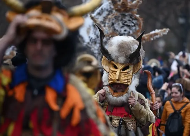 Costumed people, mask dancers called Kukeri, perform a traditional dance during the Surva Festival to ward off evil spirits in Sofia, Bulgaria, 09 January 2022. In ancient times, the old Thracians held the Kukeri Ritual Games in honor of god Dionysus – known as a god of wine and ecstasy. Even today these games are also known as the Dionysus' games. Among the Kukeri (singular: kuker) dancers' are many characters, including Dionysus and his satyrs as well as others from deep history such as the tsar, harachari, plyuvkachi, startzi, and pesyatzi. (Photo by Vassil Donev/EPA/EFE)