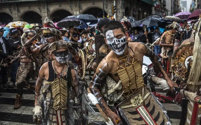 Attendees perform indigenous dance during a celebration for Andres Manuel Lopez Obrador, Mexico's president, not pictured, in Mexico City, Mexico, on Monday, July 1, 2019. Mexico celebrated the one year anniversary of the election of President Lopez Obrador. (Photo by Alejandro Cegarra/Bloomberg)