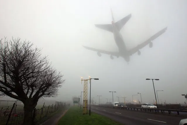 Planes land in fog at Heathrow Airport, west London, as heavy fog covers a many parts of the south east, on April 1, 2014. (Photo by Steve Parsons/PA Wire)