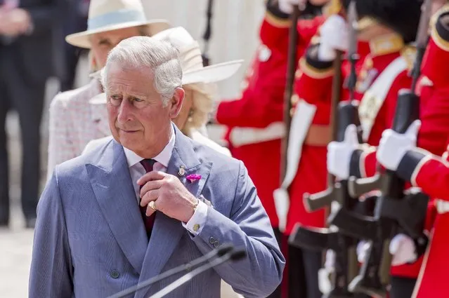 Britain's Prince Charles adjusts his tie as he walks ahead of Camilla, the Duchess of Cornwall, as they speak with the troops during a ceremony for the opening of the Hougoumont farm as part of the bicentennial celebrations for the Battle of Waterloo, near Waterloo, Belgium June 17, 2015. The commemorations for the 200th anniversary of the Battle of Waterloo will take place in Belgium on June 19 and 20. REUTERS/Geert Vanden Wijngaert/Pool