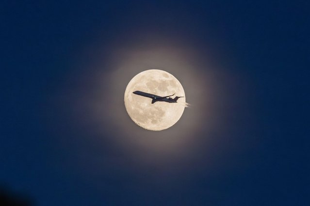 Plane is seen close to the full moon is seen in New York in the United States on the night of this Tuesday, May 21, 2024. (Photo by William Volcov/ZUMA Press Wire/Alamy Live News)