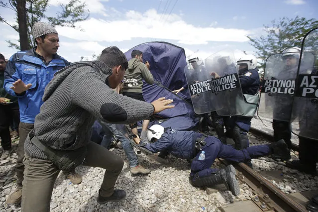 Migrants and refugees scuffle with Greek policemen during a protest at the northern Greek border point of Idomeni, Greece, Thursday, May 5, 2016. Migrants and refigees protested against the poor camp conditions and the closed border. (Photo by Gregorio Borgia/AP Photo)