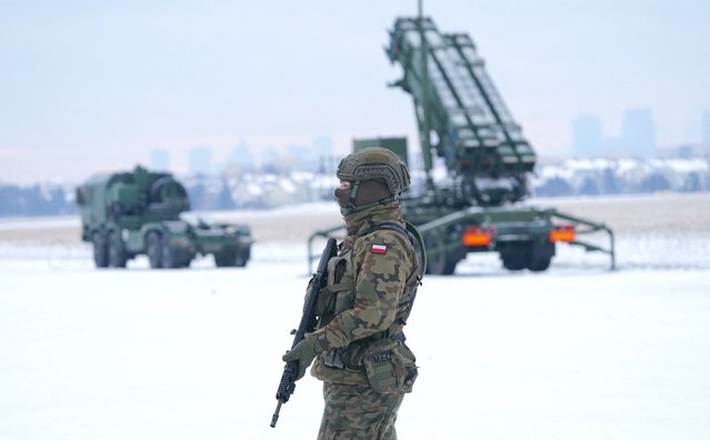 A soldier stands in front of a PATRIOT (Phased Array Tracking Radar to Intercept on Target) surface-to-air missile system during a military exercise at Warsaw Babice Airport, Poland on February 7, 2023. Patriot missile systems purchased by Poland last year have been redeployed to the Polish captital for military exercises. (Photo by Janek Skarzynski/AFP Photo)