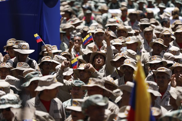 Members of the Bolivarian Militia gather for a rally marking the 22nd anniversary of the late President Hugo Chavez's return to power after a failed coup attempt, in Caracas, Venezuela, April 13, 2024. (Photo by Pedro Ramsee/AP Photo)