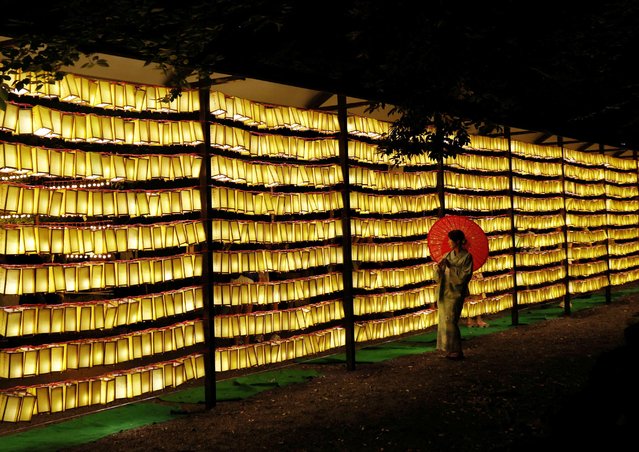 A woman in yukata, or casual summer kimonos, holds an umbrella in front of lanterns during the annual Mitama Festival at the Yasukuni Shrine in Tokyo, Japan, on July 13, 2024. About 30,000 lanterns lighted up the shrine, where more than 2.4 million war dead are enshrined, during the four-day festival which begun today. (Photo by Kim Kyung-Hoon/Reuters)