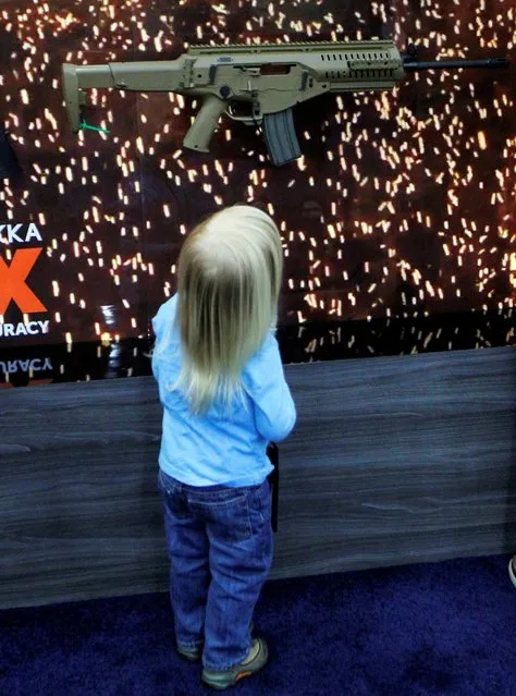 A young child looks over a gun on the exhibit floor at the National Rifle Association's annual meetings & exhibits show in Louisville, Kentucky, May 21, 2016. (Photo by John Sommers II/Reuters)