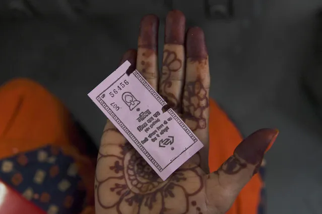 A woman travelling on a Delhi Transport Corporation bus shows a pink ticket in New Delhi on October 29, 2019, allowing her to a free ride following a Delhi goverment travel scheme distributing free bus tickets for women safety and empowerment. India's national capital on October 29 rolled out a scheme to make public transport free for women, authorities said. (Photo by Sajjad Hussain/AFP Photo)