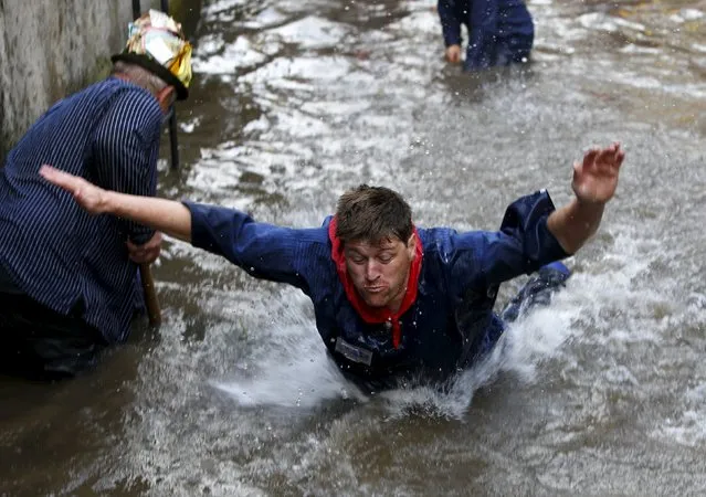 Fisherman Stefan Albrecht reacts after catching a trout in a small river while celebrating Fischertag (Fisherman's Day) in downtown Memmingen, southern Germany, July 25, 2015. (Photo by Michaela Rehle/Reuters)