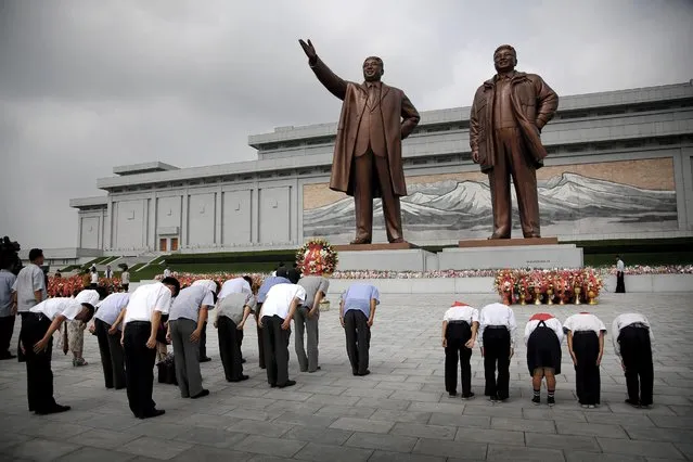 North Koreans bow in front of bronze statues of the late leaders Kim Il Sung, left, and Kim Jong Il at Munsu Hill, Monday, July 27, 2015, in Pyongyang, North Korea. (Photo by Wong Maye-E/AP Photo)