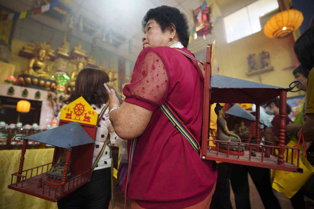 A devotee carries a statue of Buddha inside a temple during Wesak day celebration in Ipoh, Malaysia, Wednesday, May 22, 2024. (Photo by Vincent Thian/AP Photo)