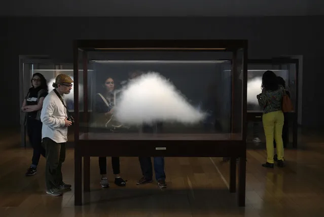 People watch Argentine conceptual artist Leandro Erlich's installation "Clouds" of his exhibition entitled “Liminal” at the Museum of Latin American Art (MALBA) in Buenos Aires on October 18, 2019. The popularity of Erlich, 46, is such that some call him “The Messi of Argentinian art“. His works, which could be a magic trick or an illusion, become viral in social networks and mark records of visits. His most monumental work – a sand traffic jam in real size – will be unveiled next week in Miami during the Art Basel. (Photo by Juan Mabromata/AFP Photo)