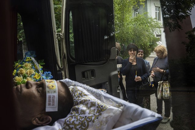 Svitlana Nosik, 56, looks at her brother Vitali Holodniak, 46, during his funeral in Kherson, Ukraine, Wednesday, June 14, 2023. Holodniak was killed, according to Ukrainian authorities, by Russian in Kardashynka village during an evacuation of residents from the flooded area near Kherson. (Photo by Evgeniy Maloletka/AP Photo)