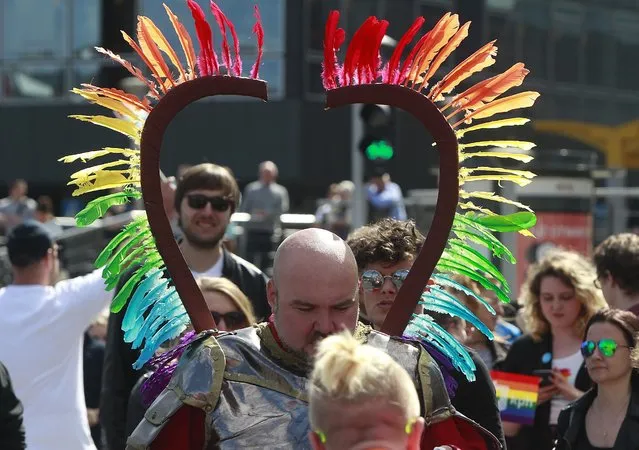 Warsaw residents with rainbow symbol walk in a colorful annual Equality Parade to show their support for sexual minority groups in Warsaw, Poland, Saturday, June 11, 2016. The 16th parade Saturday is held at a time when views concerning minorities are getting radicalized under a right-wing government that took office in November. A visible police presence accompanied the march. (Photo by Czarek Sokolowski/AP Photo)
