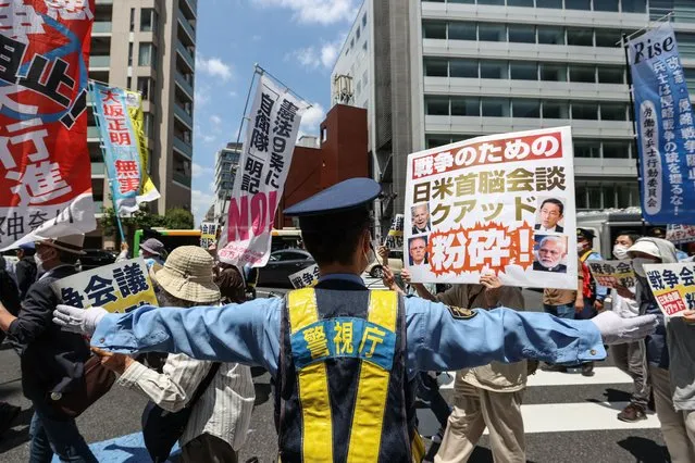 People hold signs and chant slogans during the march to protest against Quad Summit on May 24, 2022 in Tokyo, Japan. President Biden arrived in Japan after his visit to South Korea, part of a tour of Asia aimed at reassuring allies in the region. Biden will also take part in the Quad Leaders' summit during his visit. (Photo by Takashi Aoyama/Getty Images)