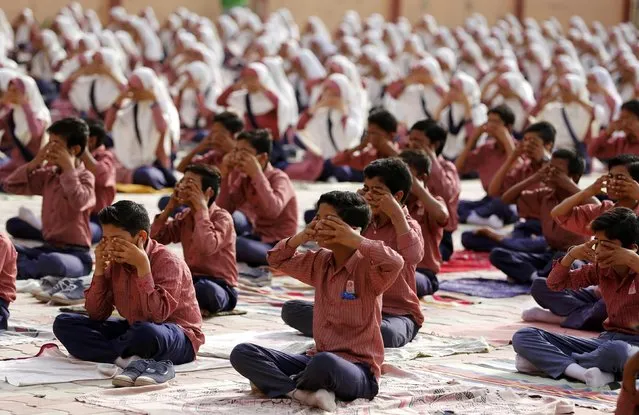Students practice yoga during a training session ahead of World Yoga Day in Ahmedabad, India, June 16, 2016. (Photo by Amit Dave/Reuters)