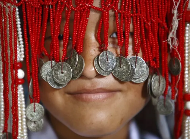A girl dressed in traditional attire participates in celebrations on the 79th birthday of the Dalai Lama in Kathmandu July 6, 2014. Nepal ceased issuing refugee papers to Tibetans in 1989 and recognizes Tibet to be a part of China. (Photo by Navesh Chitrakar/Reuters)
