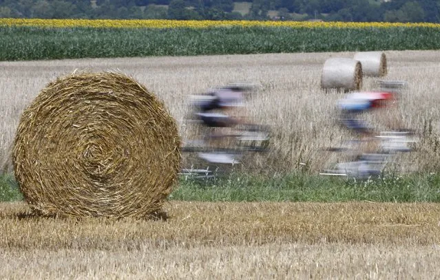 The pack of riders cycles on its way during the 197.5km 13th stage of the Tour de France cycling race between Saint-Etienne and Chamrousse, July 18, 2014. Picture taken with low exposure. (Photo by Jean-Paul Pelissier/Reuters)