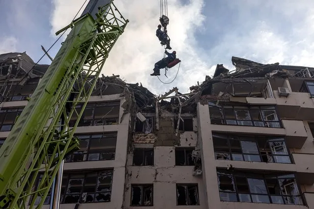 Rescuers in action next to a damaged residential building following Russian airstrikes in the Shevchenkivskiy district of Kyiv (Kiev), Ukraine, 26 June 2022. Multiple airstrikes hit the center of Kyiv in the morning. Russian troops on 24 February entered Ukrainian territory, starting the conflict that has provoked destruction and a humanitarian crisis. (Photo by Roman Pilipey/EPA/EFE)