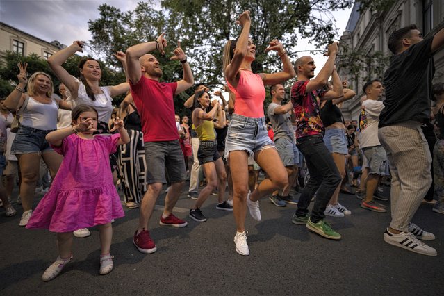 People dance on Calea Victoriei, a main avenue in Bucharest, Romania, during the Dance Night event, Saturday, August 26, 2023. More than 200 dancers from 45 studios danced along with passersby covering a wide variety of dance styles. (Photo by Andreea Alexandru/AP Photo)