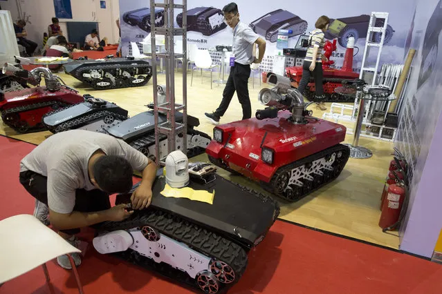 Tracked autonomous vehicles are prepared a day before the opening of the World Robot Conference held in Beijing, China, Tuesday, August 22, 2017. (Photo by Ng Han Guan/AP Photo)