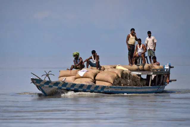 People transport sacks of rice through a boat at a flooded village in Morigaon district in the northeastern state of Assam, August 20, 2017. (Photo by Anuwar Hazarika/Reuters)