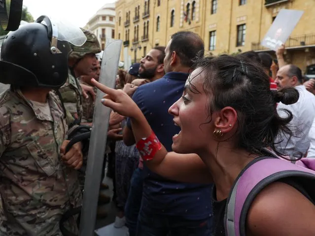 A demonstrator gestures as she talks with a Lebanese army member during a protest as Lebanon marks the two-year anniversary of the August 2020 Beirut port explosion, in Beirut, Lebanon on August 4, 2022. (Photo by Mohamed Azakir/Reuters)