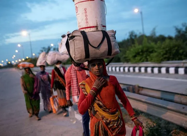 Migrant workers carry their belongings as they walk along a road to return to their villages, during a 21-day nationwide lockdown to limit the spreading of coronavirus disease (COVID-19), in New Delhi, India, March 26, 2020. (Photo by Danish Siddiqui/Reuters)
