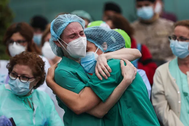 Health workers wearing protective face masks react during a tribute for their co-worker Esteban, a male nurse that died of the coronavirus disease, amid the coronavirus disease (COVID-19) outbreak, outside the Severo Ochoa Hospital in Leganes, Spain, April 13, 2020. (Photo by Susana Vera/Reuters)