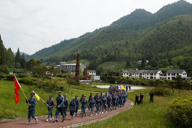 Participants dressed in replica red army uniforms march during a Communist team-building course extolling the spirit of the Long March, organised by the Revolutionary Tradition College, in the mountains outside Jinggangshan, Jiangxi province, China, September 14, 2017. (Photo by Thomas Peter/Reuters)
