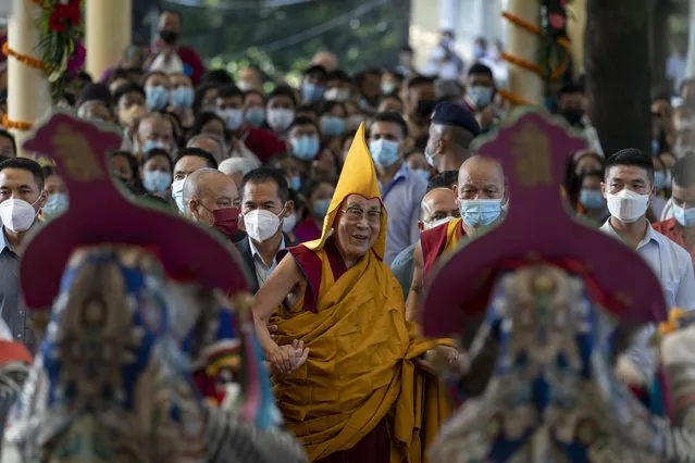 Tibetan spiritual leader the Dalai Lama, center,  in a yellow ceremonial hat, watches a welcome dance performed by Tibetan artists, as he arrives at the Tsuglakhang temple in Dharmsala, India, Wednesday, September 7, 2022. Exiled Tibetans prayed for the long life of their spiritual leader. (Photo by Ashwini Bhatia/AP Photo)