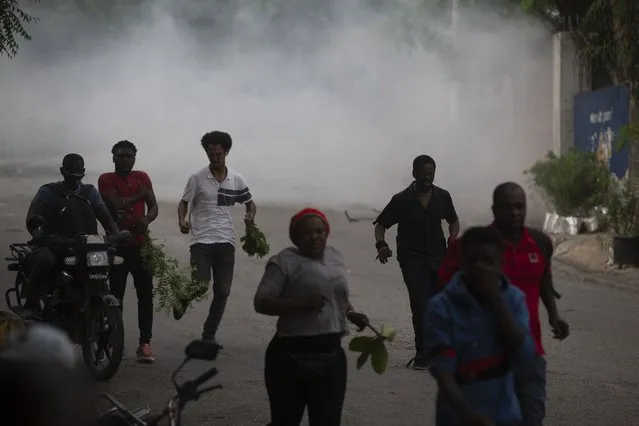 Protesters are dispersed by tear gas thrown by the police during a protest in Port-au-Prince, Haiti, Monday, August 22, 2022. (Photo by Odelyn Joseph/AP Photo)