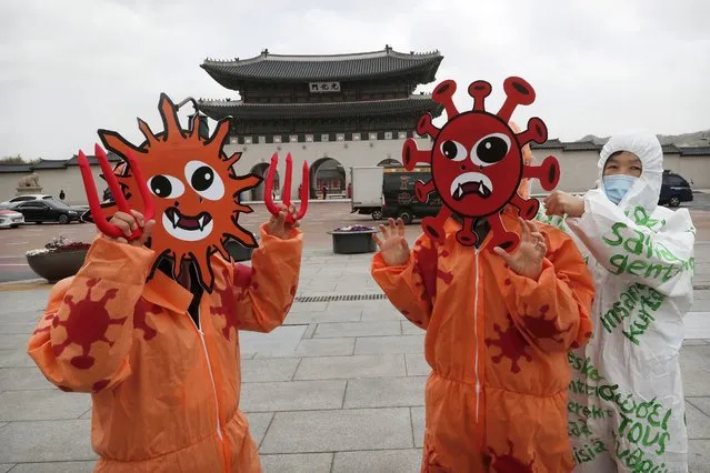 Members of the Environmental Health Citizens' Association of Korea wearing masks representing the viruses perform during an event to celebrate the 50th anniversary of Earth Day at Gwanghwamun Square in Seoul, South Korea, Wednesday, April 22, 2020. For most people, the new coronavirus causes only mild or moderate symptoms, such as fever and cough. For some, especially older adults and people with existing health problems, it can cause more severe illness, including pneumonia. (Photo by Ahn Young-joon/AP Photo)