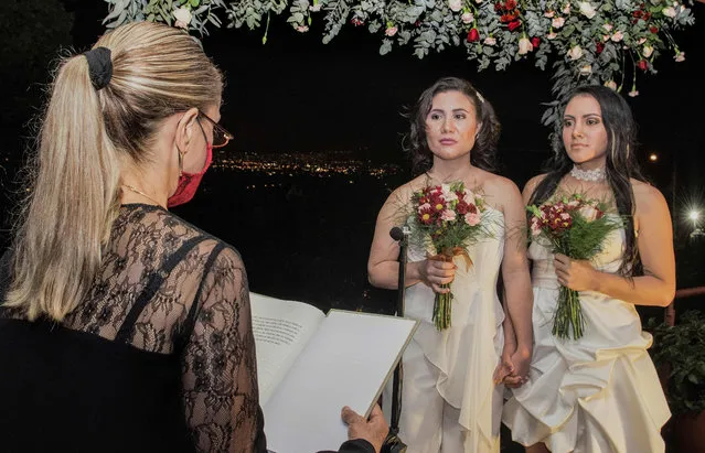 Same-s*x newlyweds Alexandra Quiros (C) and Dunia Araya (R) stand before a lawyer during their wedding in Heredia, Costa Rica, on May 26, 2020. Costa Rica legalised same-s*x marriage on May 26, becoming the first Central American country to do so and sparking an emotional response from rights campaigners as the first weddings were held overnight. (Photo by Ezequiel Becerra/AFP Photo)