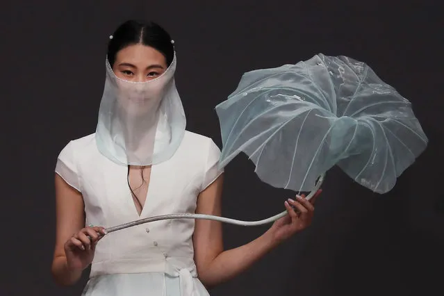 A model holds a lotus leaf as she presents a “Heaven Gaia” creation by Chinese designer Xiong Ying during the China Fashion Week in Beijing, Saturday, November 4, 2017. (Photo by Andy Wong/AP Photo)