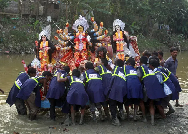 Municipal workers carry an idol of the Hindu goddess Durga for immersion in the waters of the river Hawra during the Durga Puja festival in Agartala October 3, 2014. (Photo by Jayanta Dey/Reuters)