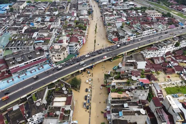 An aerial view shows flooding following torrential rain in Medan city, North Sumatra on November 19, 2022. (Photo by Muhammad Zulfan Dalimunthe/AFP Photo)
