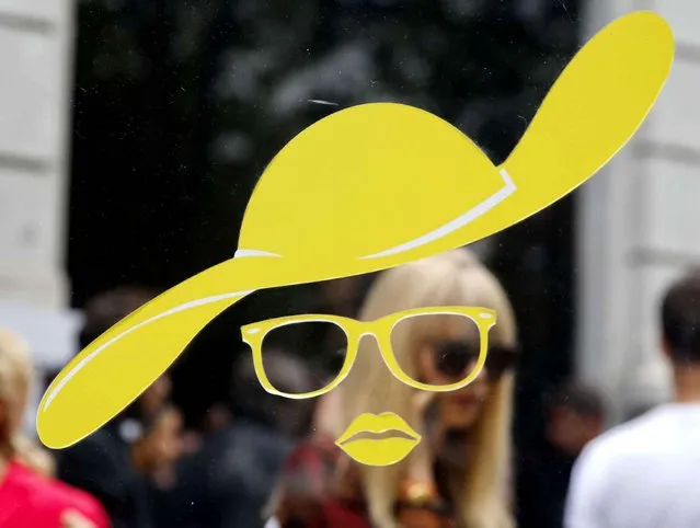 A hat, a pair of glasses and lips are printed on a glass, part of an advertising campaign in the wake of the Milan Fashion Week in Milan, Italy, Sunday, September 27, 2015. (Photo by Luca Bruno/AP Photo)