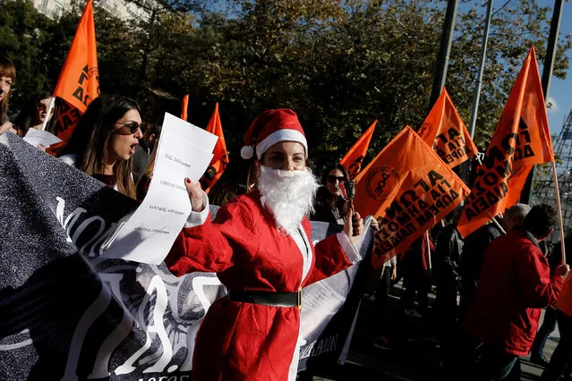A woman wears a Santa Claus costume as she takes part in a demonstration marking a 24-hour general strike against austerity in Athens, Greece, December 14, 2017. (Photo by Costas Baltas/Reuters)