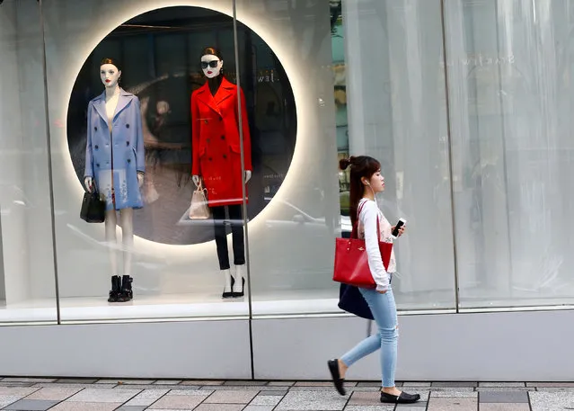 A woman walks past a fashion boutique in a shopping district in Tokyo, Japan, May 30, 2016. (Photo by Thomas Peter/Reuters)