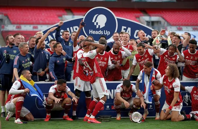 The Arsenal squad celebrate after the FA Cup Final match between Arsenal and Chelsea at Wembley Stadium on August 01, 2020 in London, England. Football Stadiums around Europe remain empty due to the Coronavirus Pandemic as Government social distancing laws prohibit fans inside venues resulting in all fixtures being played behind closed doors. (Photo by Stuart MacFarlane/Arsenal FC via Getty Images)