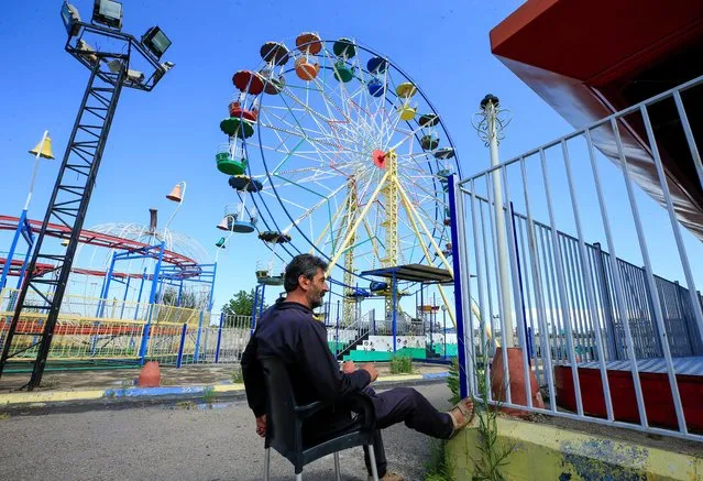 A security guard sits at an empty amusement park, on the first day of the Muslim holiday of Eid al-Fitr, amid concerns over the spread of the coronavirus disease (COVID-19), in the port city of Sidon, southern Lebanon, May 24, 2020. (Photo by Ali Hashisho/Reuters)