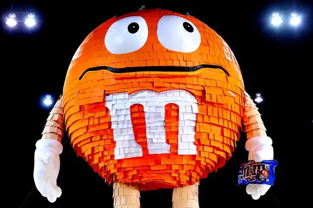 A 46 foot pinata in the form of an orange M&M candy, filled with thousands of M&M's pretzel packages, set a new Guinness World Record for the world's largest pinata in New York on August 4, 2011. (Photo by Stan Honda/AFP Photo)