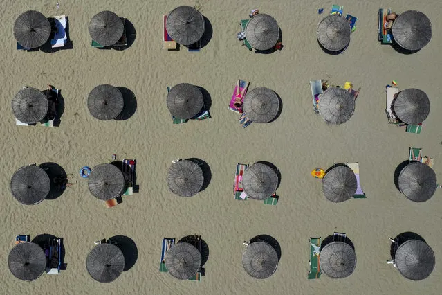 This aerial view taken on July 6, 2019, shows parasols on a beach of the Adriatic Sea in Durres, as a heatwave sweeps through Europe. Temperatures rise to 39 degrees Celsius in Albania. (Photo by Gent Shkullaku/AFP Photo)